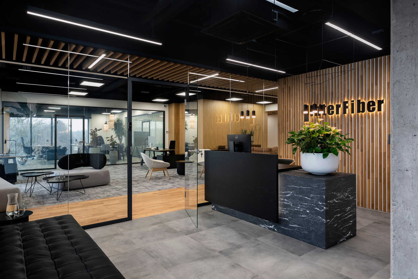strefa wejściowa, biuro Interfiber, obłe sofy, organiczne kształty, czarny sufit, projekt wnętrza biura Purple Pracownia